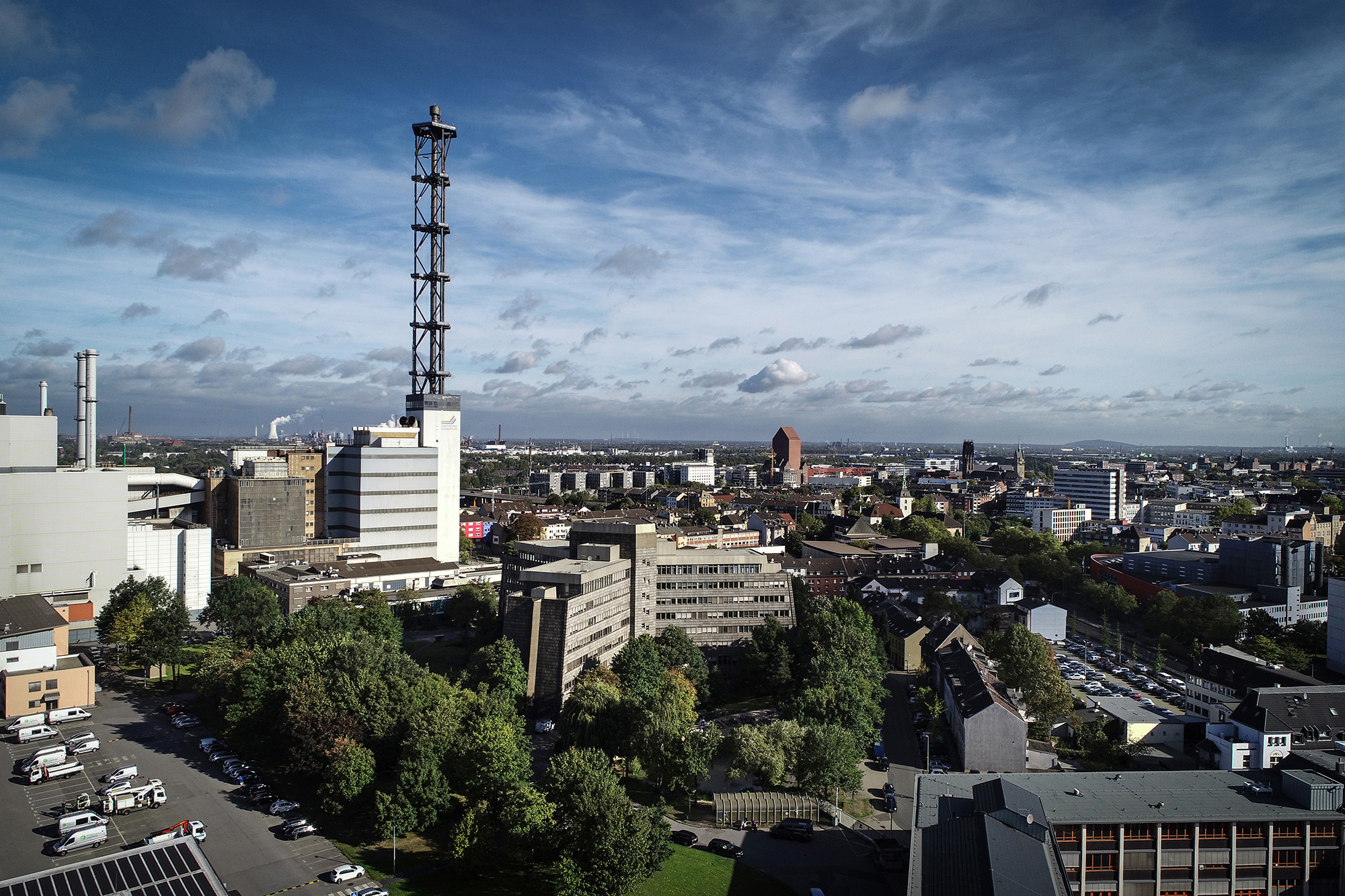 DVV-Zentrale mit Stadtwerketurm und umliegender Bebauung bei Wolkenhimmel